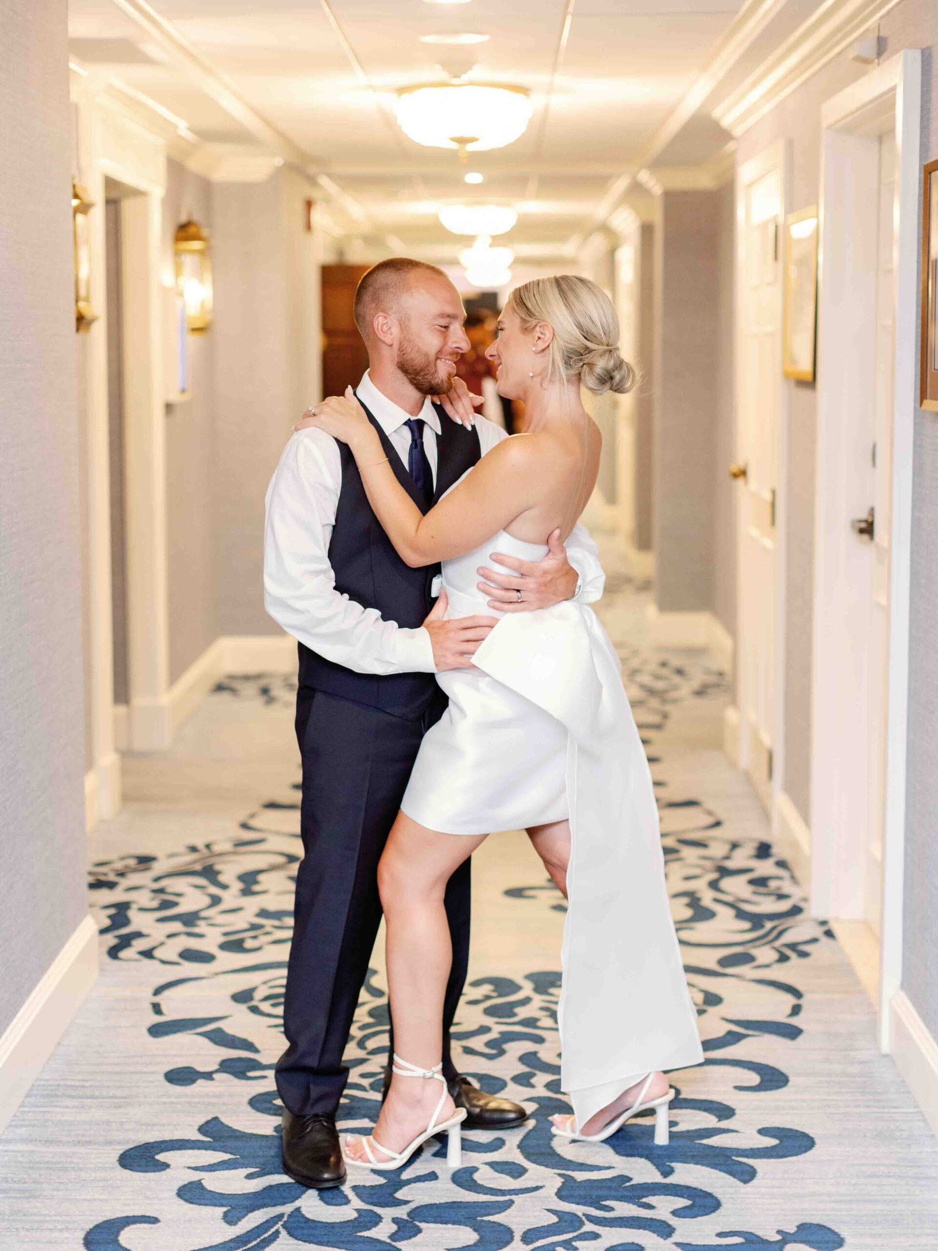 Bride and groom embracing in a hotel hallway